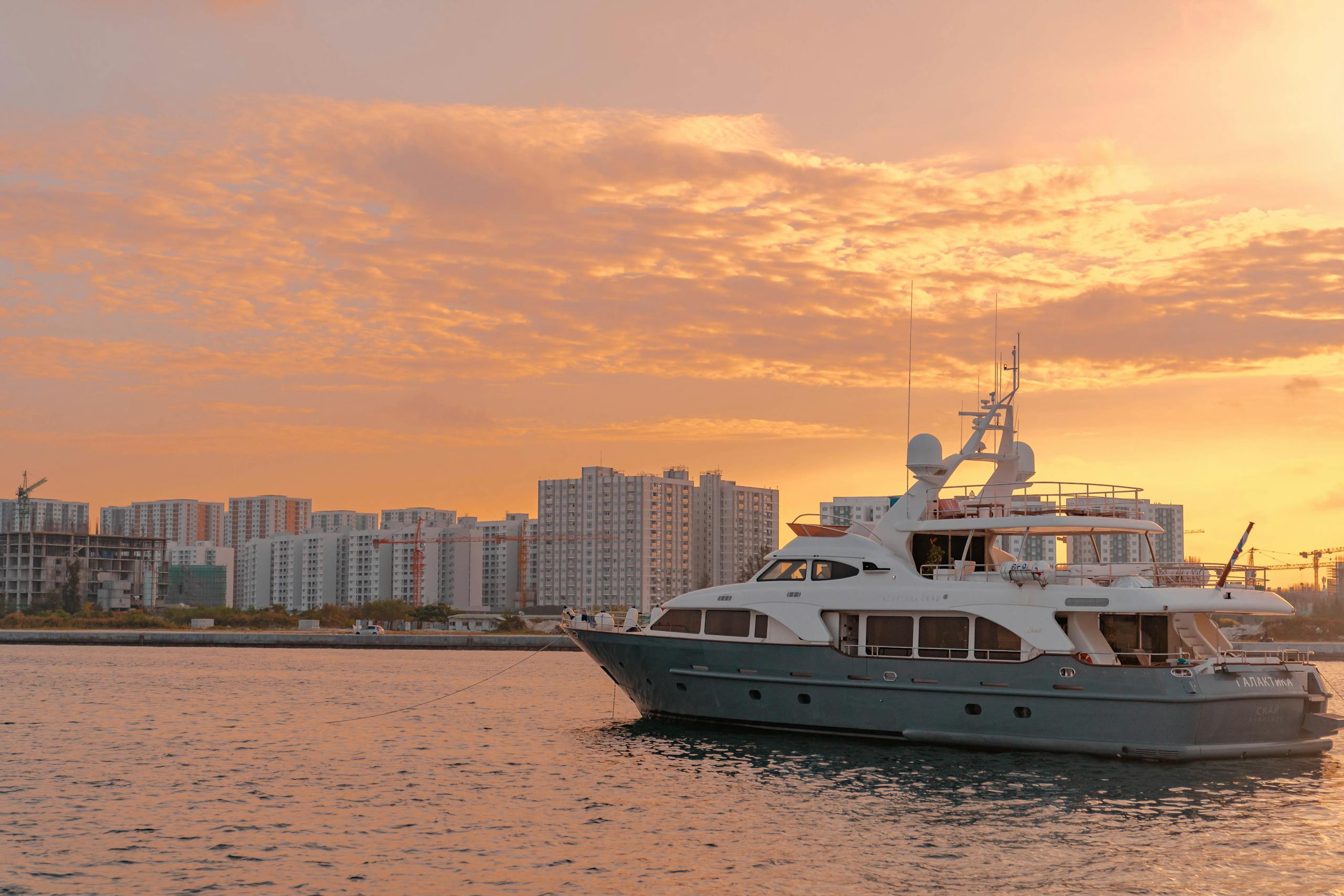 Luxury yacht on calm blue water at sunset